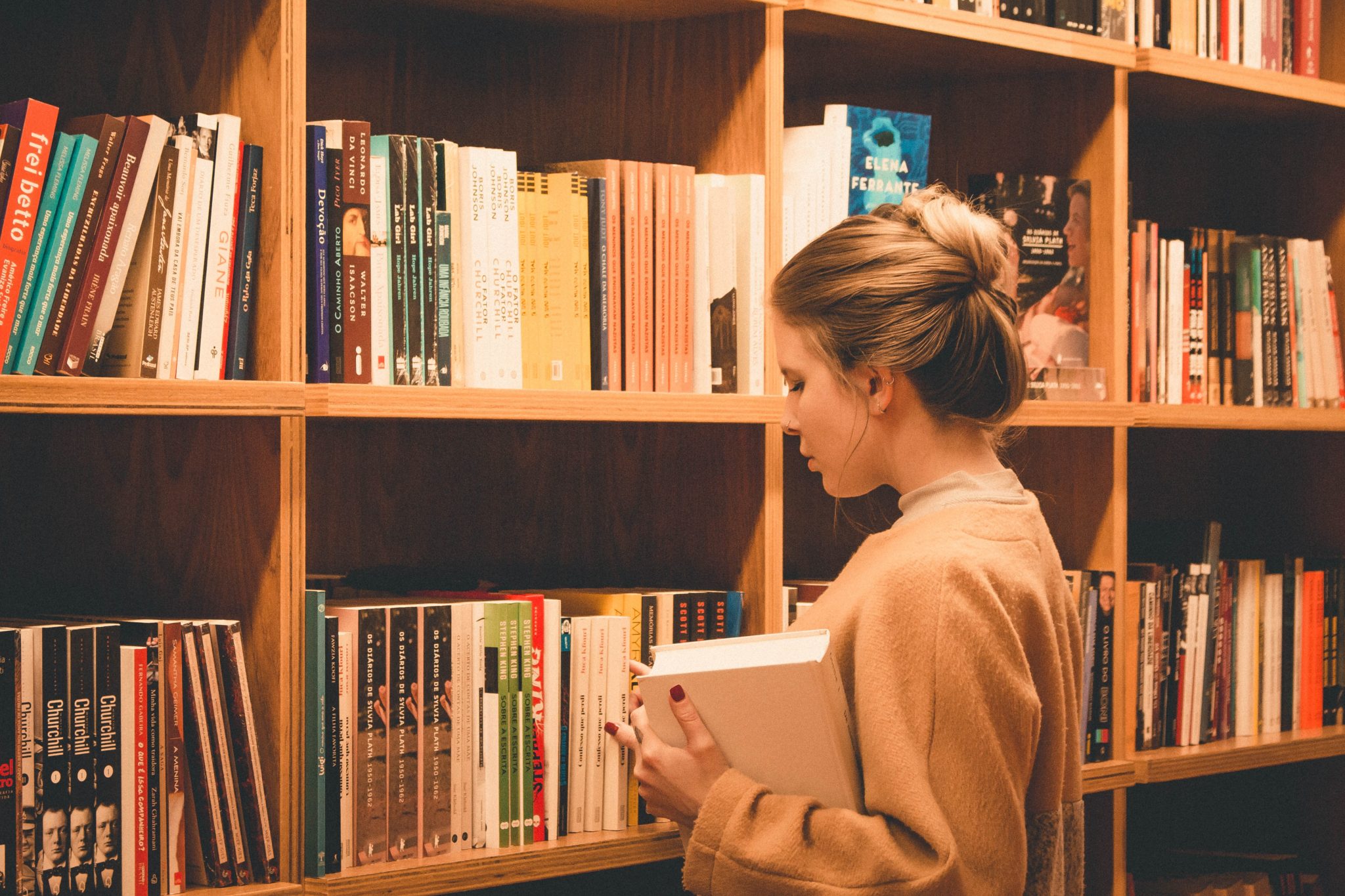 Girl picking books on a library